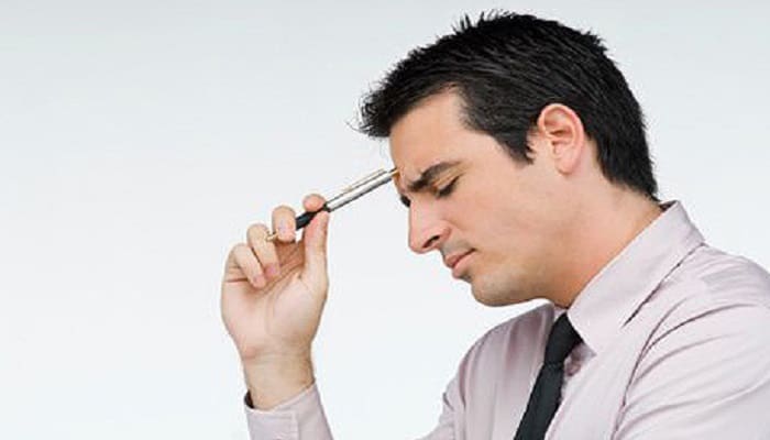 Close-up of a businessman holding a pen and thinking