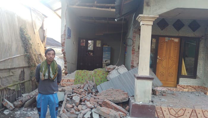 Taufik berdiri di depan rumahnya yang hancur akibat gempa 7 SR di Dusun Jorong, Desa Sembalun Bumbung, Sembalun, Lombok Timur. Foto : Hilman'/INA