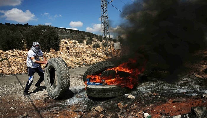 Demonstran di Gaza membakar ban sebagai bentuk protes terhadap blokade yang dilakukan Israel. Foto: JITU