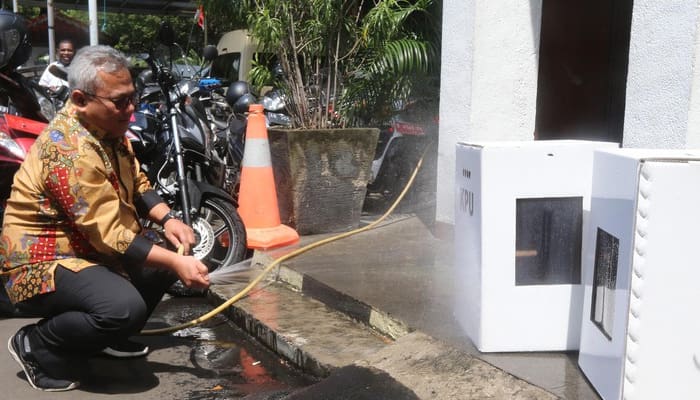 Ketua KPU Arief Budiman menyemprot kotak suara kardus dengan air. Foto: Detik