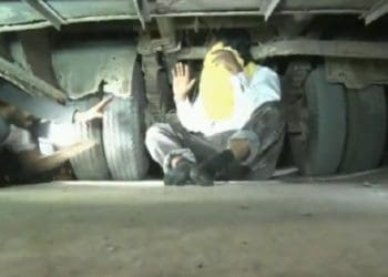 Pria sembunyi di kolong bus. Foto: The Express Tribune