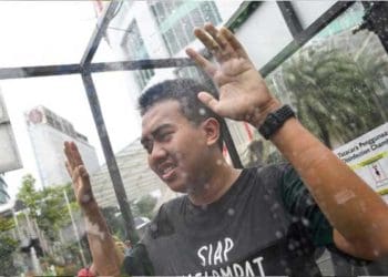 Warga disterilkan dengan ciaran disinfektan. Foto: Detik