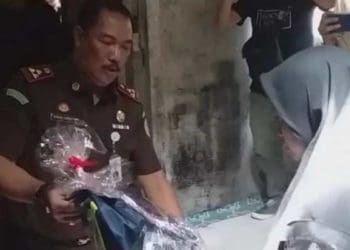 Kepala Kejaksaan Negeri Garut, Sugeng Hariadi, memberikan bantuan peralatan sekolah kepada seorang gadis pelajar MTs yang merupakan anak keluarga miskin. Foto: Viva
