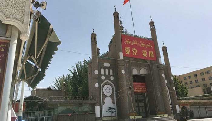 Cina Bangun Toilet Umum di Bekas Bangunan Masjid yang Dihancurkan 1 Masjid Jama, salah satu masjid di Cina dihiasi dengan bendera Tiongkok dan spanduk propaganda bertuliskan 'Cintai Partai, Cintai Negara' di daerah Kargilik di prefektur Kashgar. Foto: RFA.ORG